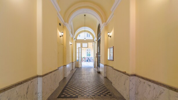 En hall med ett rutmönstrat golv, väggar av marmor och ett tak med valv.