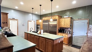 A modern kitchen with wooden cabinets, stainless steel appliances, and a central island.