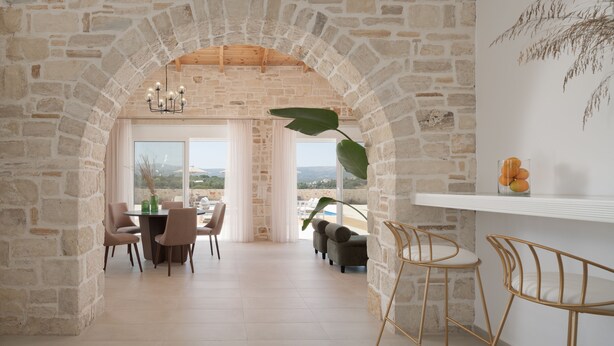 A stone-walled dining area with a view of the landscape.