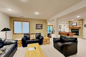 A living room with leather sofas, a coffee table, a pool table, and a fireplace. - Wonderful Home Away From Home - Free Night (Galena)