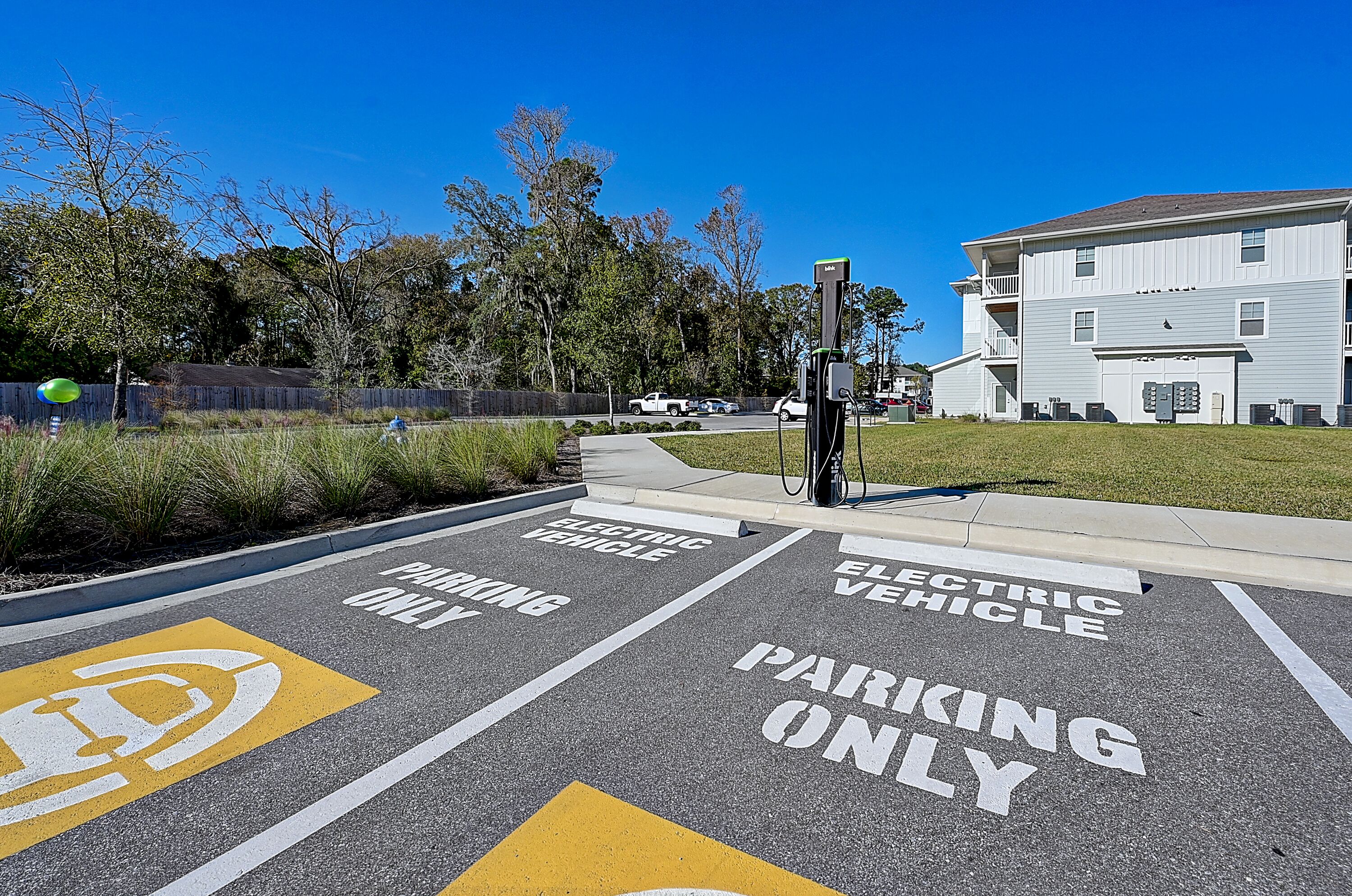 Een parkeerplaats, aangegeven voor elektrische voertuigen, met een oplaadpunt.