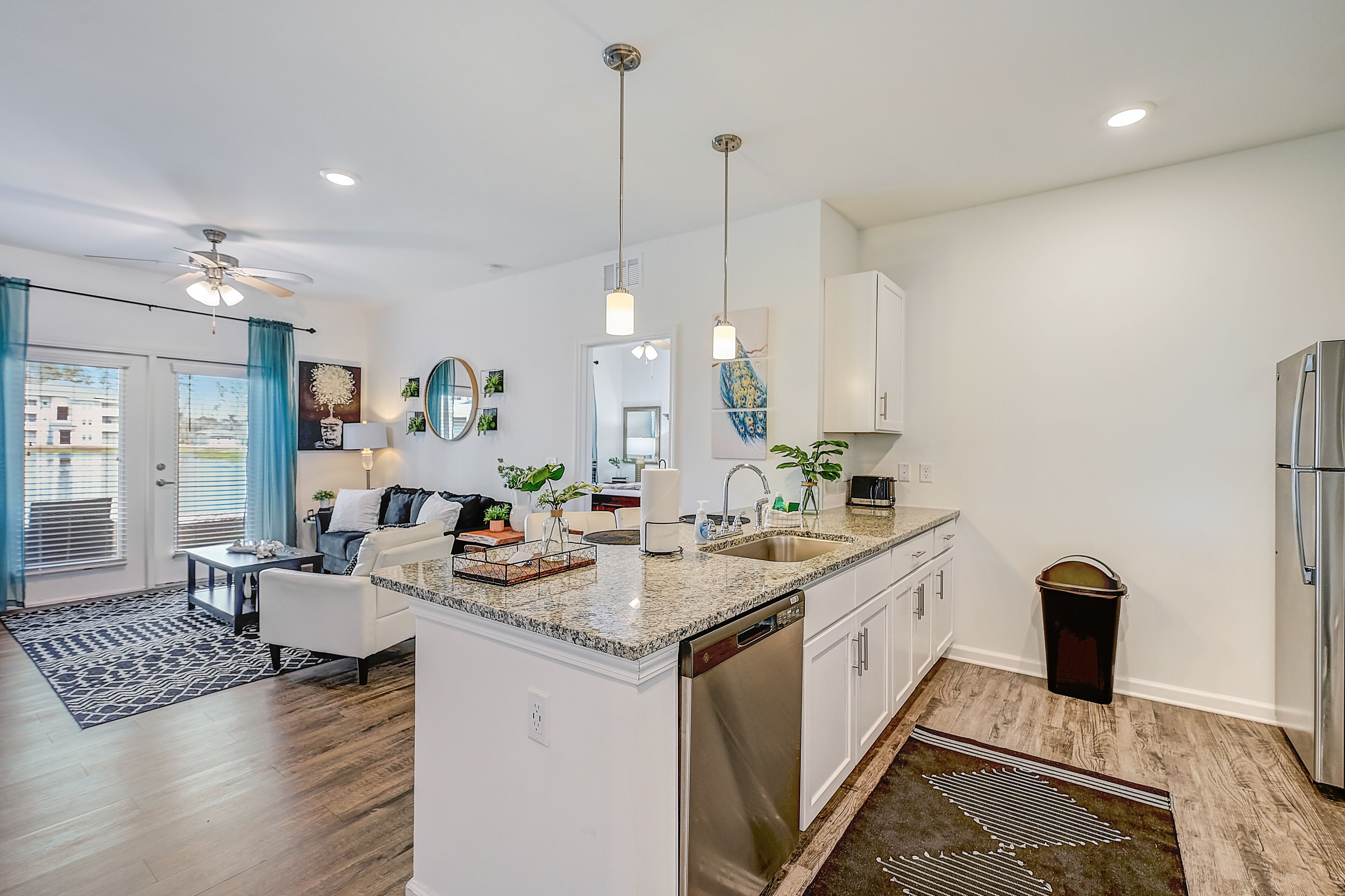 A modern kitchen with a central island, stainless steel appliances, and pendant lighting.