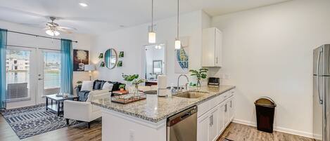 A modern kitchen with a central island, stainless steel appliances, and pendant lighting.