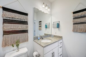 A bathroom with a large mirror, a granite countertop sink, and a toilet paper holder. - Stylish & Cozy 2BR/2BA w/King Bed, Pool & Gym Nr I295 & Downtown (Jacksonville)