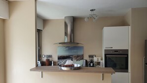 A modern kitchen with a stainless steel range hood, a coffee maker, and a microwave. - Le Touquet, Ap 67 m2, 2 Chambres, Secteur Quentovic, 5 min Plage et Centre (le Touquet Paris Plage)