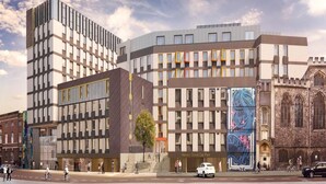 Un bâtiment moderne qui présente un mélange de styles architecturaux, notamment une partie dotée de grandes fenêtres et une autre avec une façade ornée de motifs.
