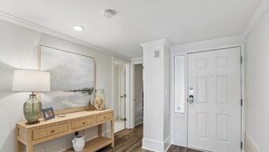 A hallway with a wooden console table, a lamp, and a framed picture on the wall.