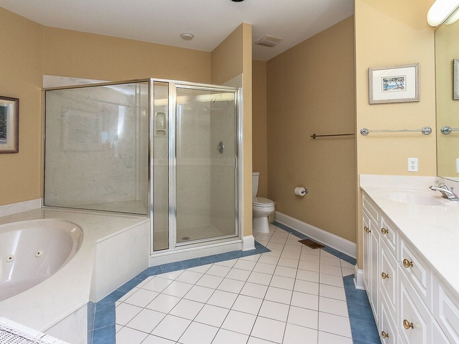 Une salle de bain avec une douche à parois de verre, une baignoire, des toilettes et un meuble-lavabo avec un miroir.