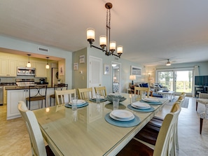 A spacious kitchen with a dining area, featuring a large island, modern appliances, and a ceiling fan.