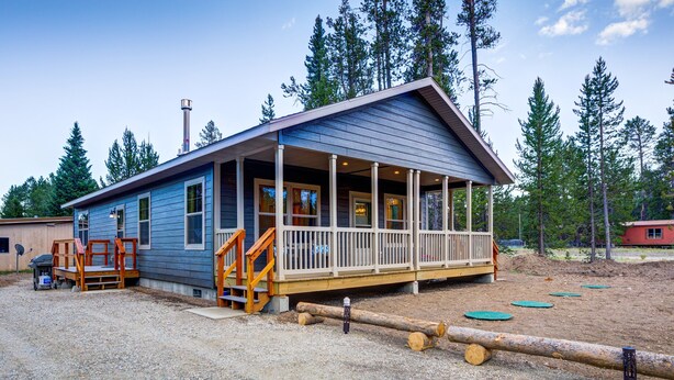 A small, single-story cabin with a porch, surrounded by trees. - Shepherd Family Retreats- Bear Cub: 2BR, 2BA home 6 min from Yellowstone National Park (West Yellowstone)