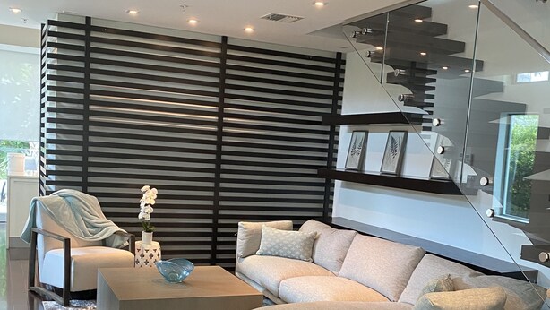 A modern living room with a sectional sofa, a coffee table, and a patterned rug.