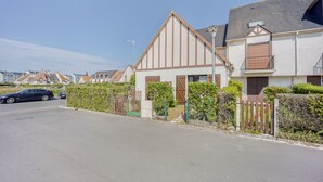 A residential street with houses featuring pitched roofs and wooden fences.