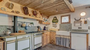 Eine Küche mit Holzschränken, einem Herd und verschiedenen Küchenutensilien.