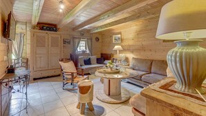 Ein gemütliches Holzinterieur mit einem runden Couchtisch, einer Couch und einem Esstisch mit Stühlen.