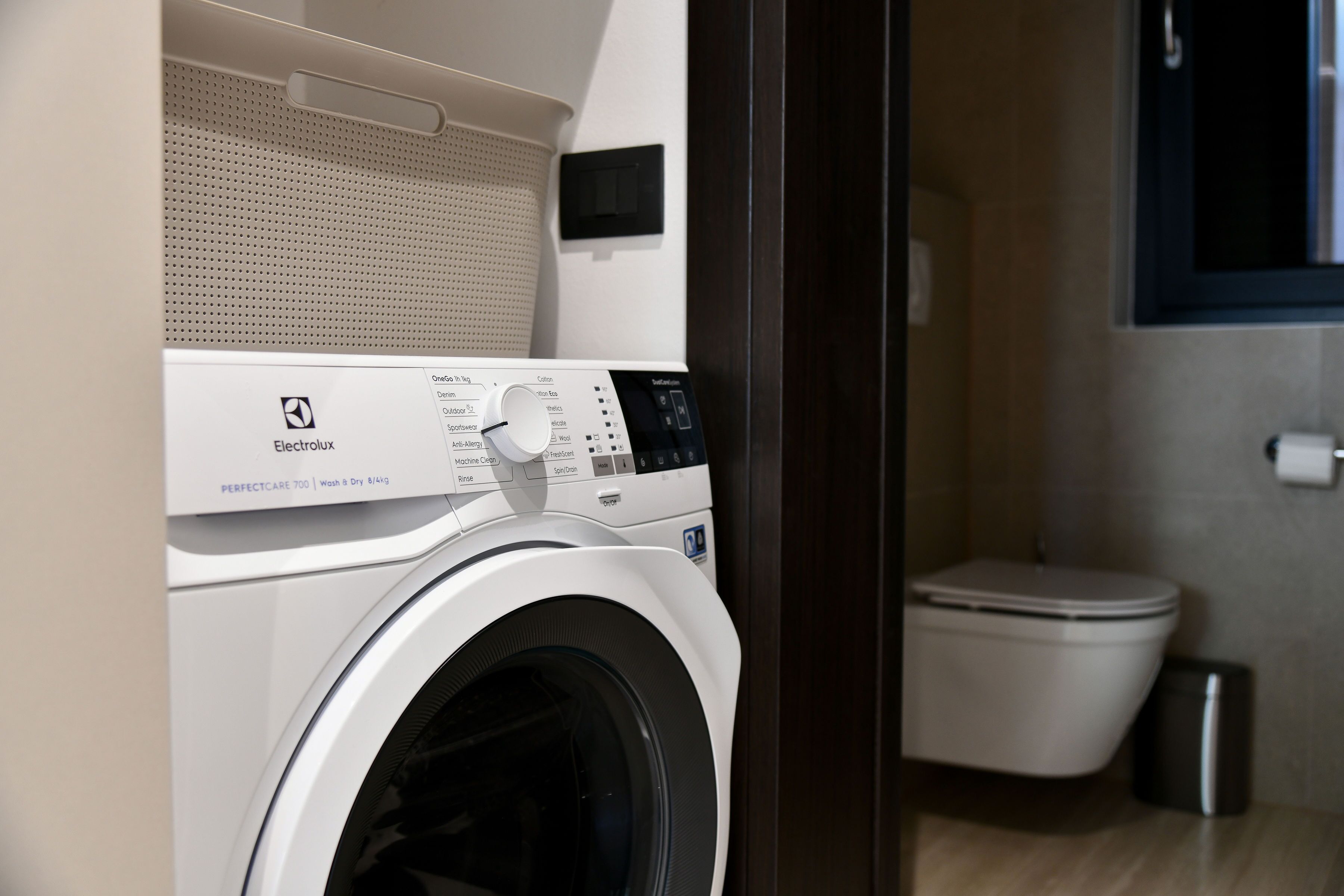Een wasmachine met voorlader en een wandrek voor het drogen van kleding.