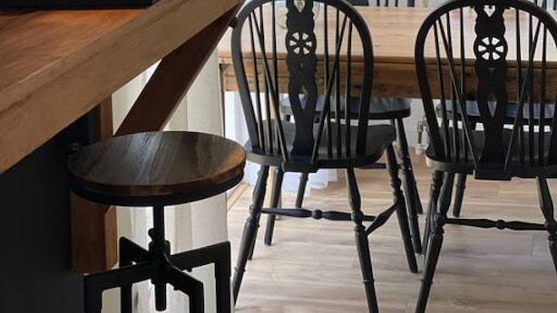 A dining area with a wooden table and black chairs, a coffee machine, and a hanging light fixture. - Raaff-71 sfeervol huis direct bij bos, duin en strand (Noordwijk)