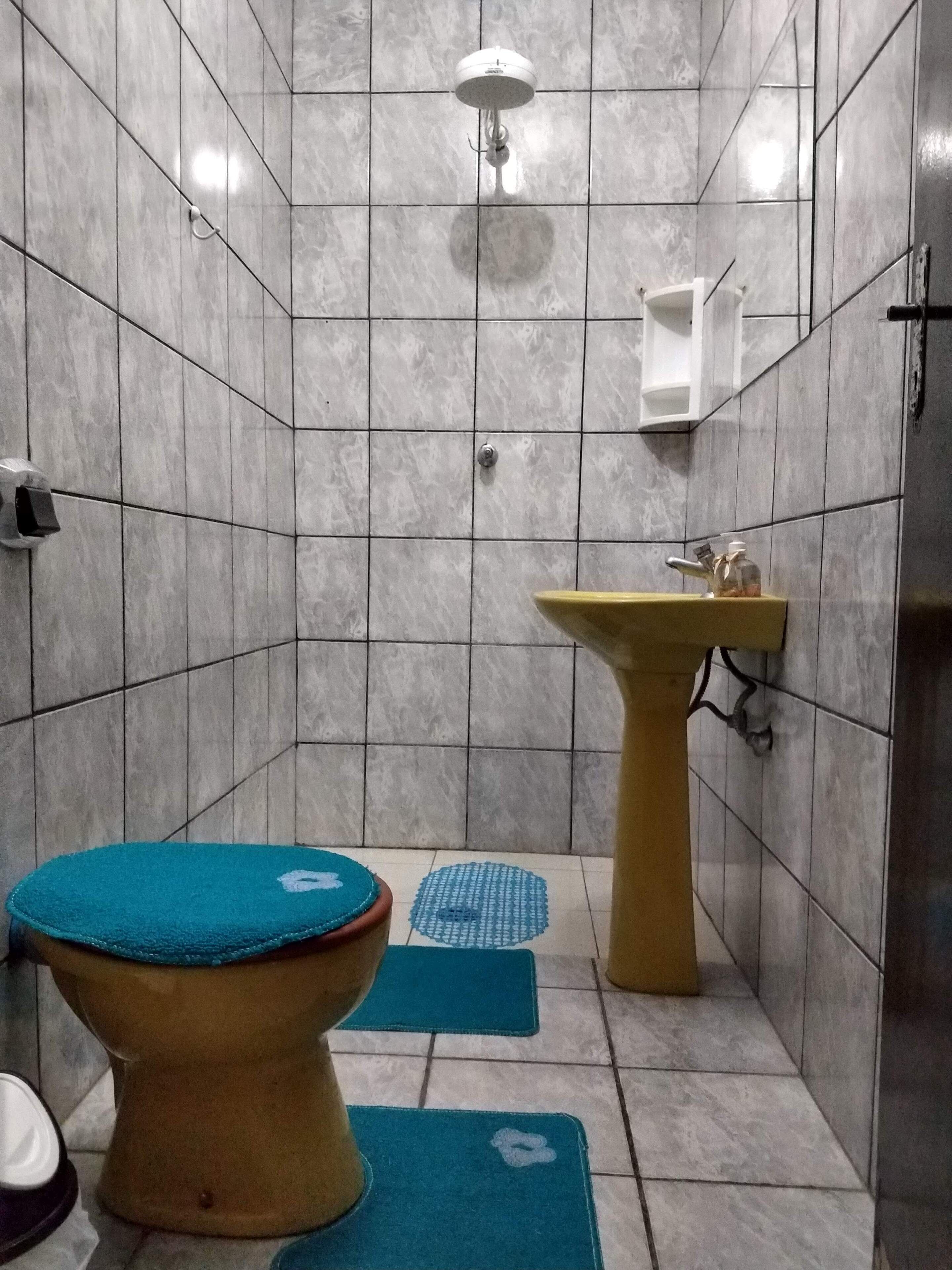 A small bathroom with a toilet, sink, and shower.
