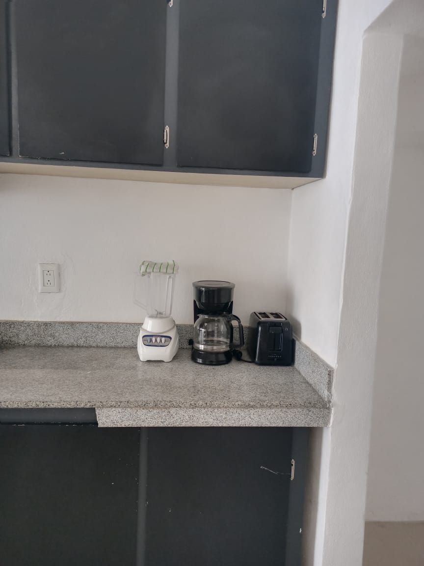 A kitchen with a countertop, a blender, a coffee maker, and a toaster.
