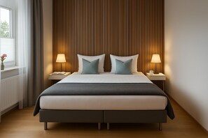 A modern hotel room with a large bed, two bedside tables, and a wooden panel wall. - Hotel Schultheiss 52 (Hamelin)