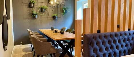 Un espace repas moderne avec une table en bois, des chaises et un banc capitonné.