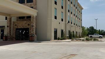 Et Comfort Suites hotel med en moderne facade, flere etager og en rummelig parkeringsplads.