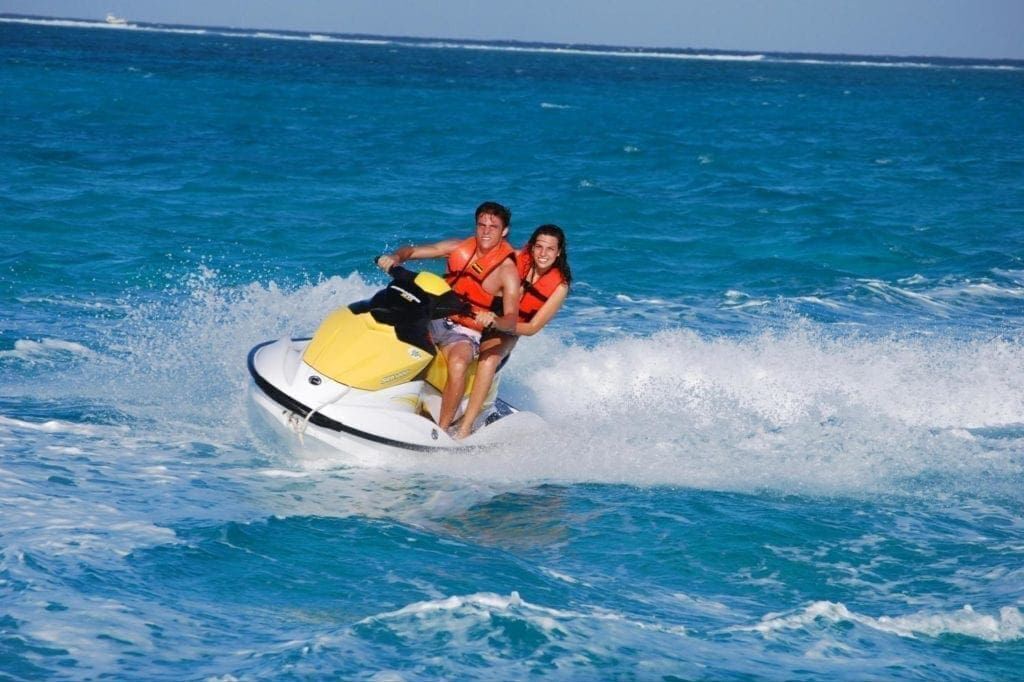 Two people on a jet ski in the ocean.