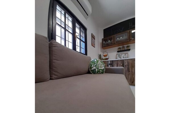 Relax in this serene living space with a comfortable sofa and a stylish storage cabinet.