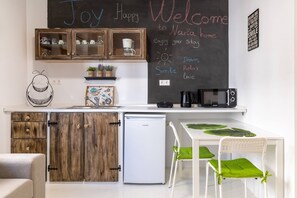 Compact kitchenette with a refrigerator, microwave, and coffee maker, perfect for preparing meals and enjoying casual dining.