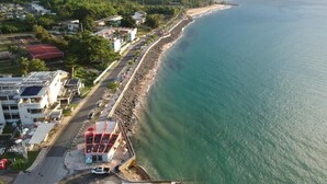 Vista aérea de una zona costera con playa, edificios y una carretera.
