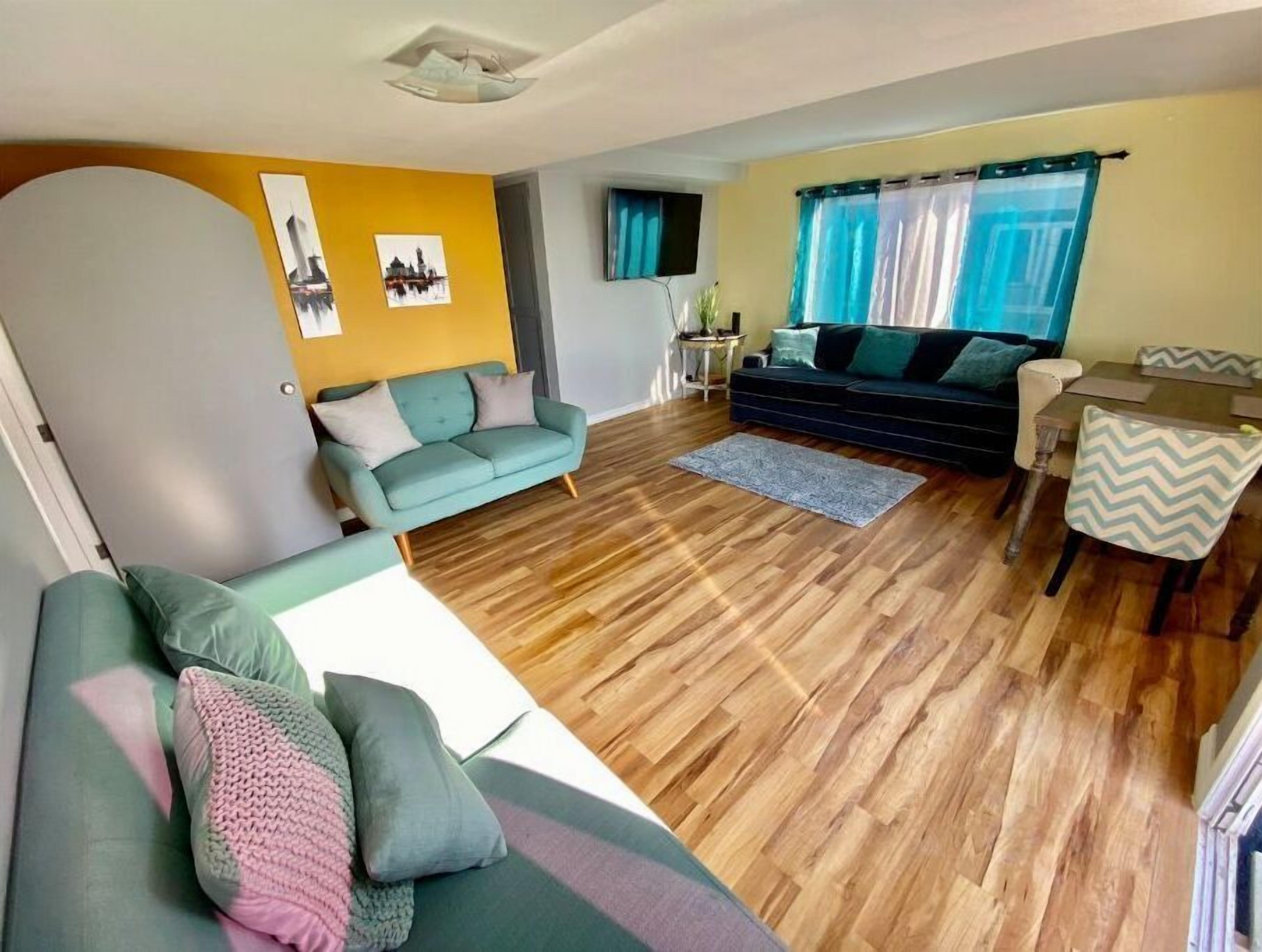 A living room with a sofa, a dining table, and a TV.
