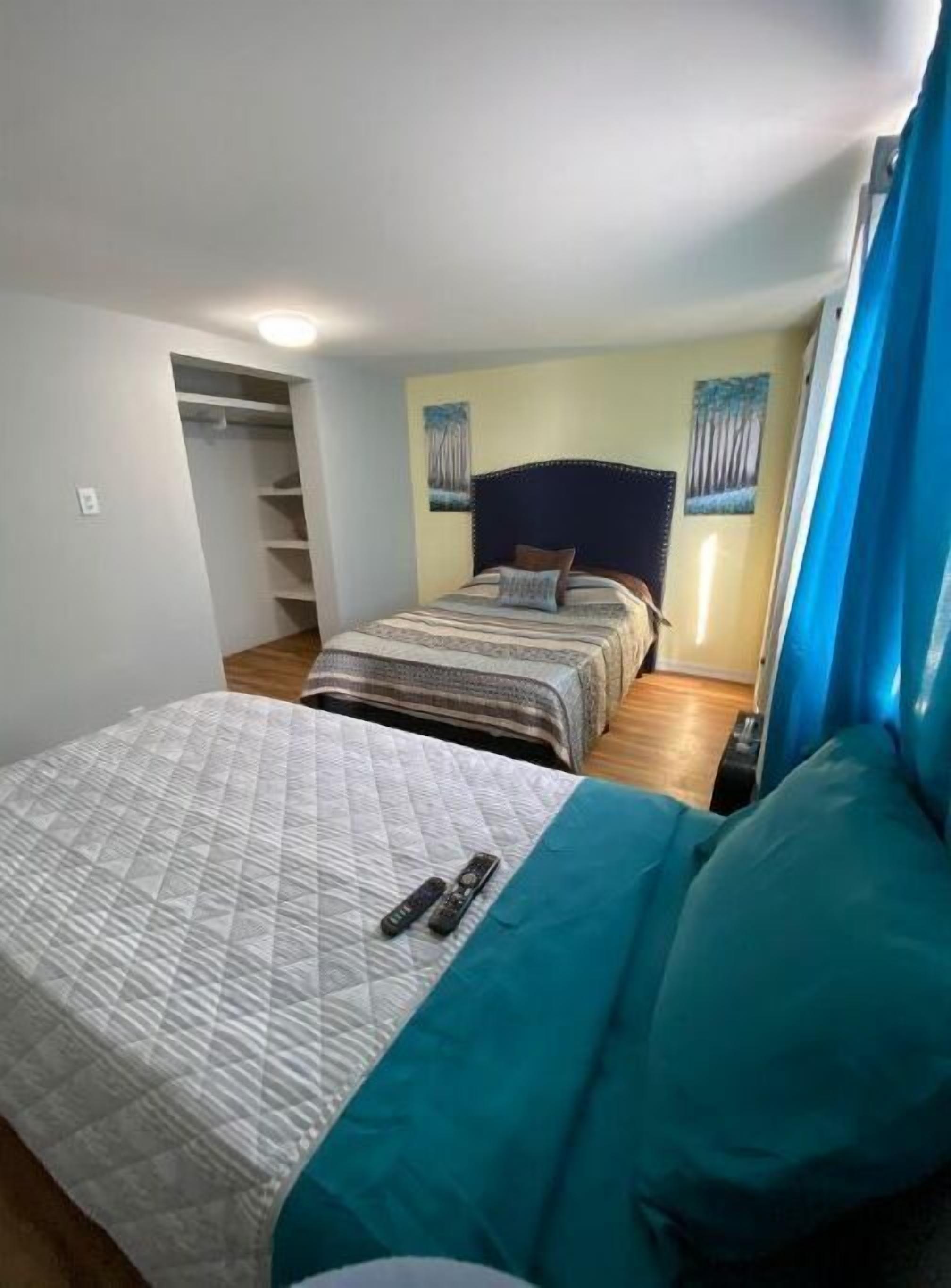 Een slaapkamer met een bed, een kledingkast en een raam met gordijnen.