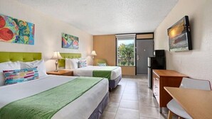 A hotel room with two beds, a desk, a TV, and artwork on the walls. - Royal Park Orlando Timeless 2 DBL Beds Room with Pool (Kissimmee)