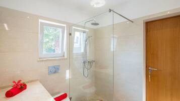Une salle de bain moderne avec une douche à parois de verre, des toilettes et un lavabo.