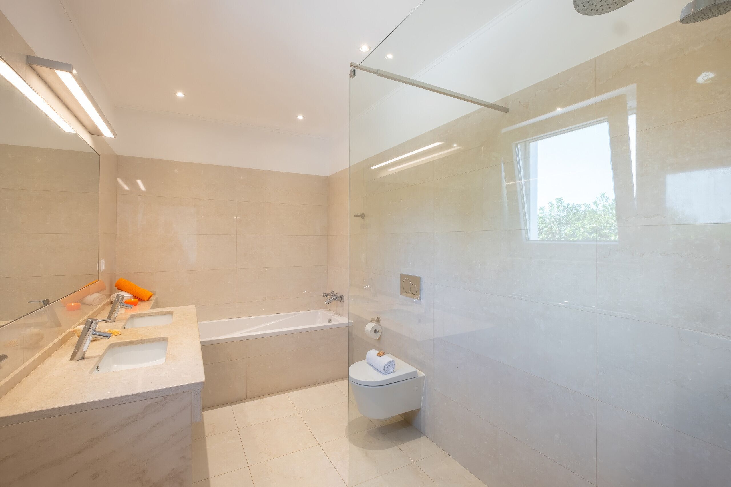 Ein modernes Badezimmer mit Badewanne, Toilette und Duschbereich.