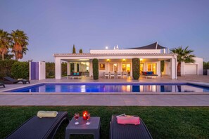 A modern house with a swimming pool, outdoor seating, and a well-maintained lawn. - Villa with BBQ and heatable pool in Carvoeiro (Carvoeiro)
