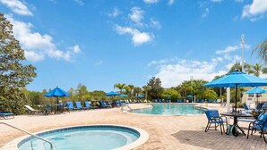 A poolside area with lounge chairs and umbrellas, a pool, and a gazebo. - Top Floor Bahama Bay Condo | 3BR/2BA | 2 Balconies | Near Disney (Davenport)