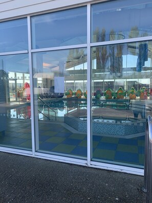 A swimming pool area with a tiled deck and a glass enclosure. - Caravan - Sleeps 6 - Parking, Pool, Facilities (Colchester)