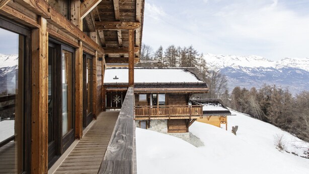 A wooden cabin with large windows and a balcony overlooking a snowy mountain landscape. - Bishorn COSY chalet 4 personnes (Les Masses)