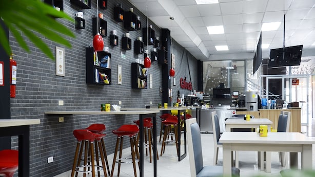 A modern restaurant with a brick wall, red bar stools, and a white table. - Large Private 3 BDR apartment in downtown Quito (Quito)