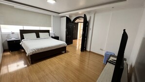 A bedroom with a bed, bedside tables, a lamp, and a desk with a chair. - Large Private 3 BDR apartment in downtown Quito (Quito)