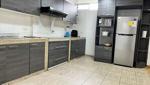 A modern kitchen with dark cabinetry, a stainless steel refrigerator, and a built-in oven. - Large Private 3 BDR apartment in downtown Quito (Quito)