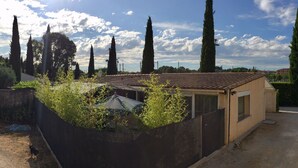 A small building with a tiled roof, surrounded by a concrete wall and vegetation. - Maisonnette with swimming pool access, on the campsite (Aix en Provence)