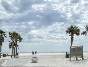 A beach with palm trees, a concrete path, and a few people walking. - Few summer dates available! Pet friendly and .1 mile to beach!  (Gulf Shores)