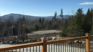A wooden deck overlooking a mountainous landscape with a clear sky. - Ski Retreat with scenic mountian and river views  (Hanover)