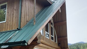 A log cabin with a wooden deck and large windows. - 6 BDRM Log Cabin on Big Fall Creek (Fall Creek)
