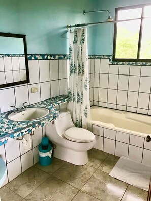 Et badeværelse med to håndvaske, toilet og badekar.