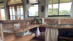 Een keuken met een betegelde achterwand, een spoelbak en een fruitschaal.