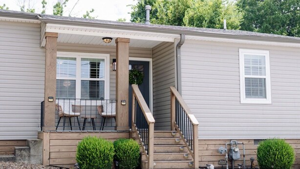 A single-story house with a front porch, a staircase, and a small outdoor seating area. - Cozy cottage, just a short walk to UofA (Fayetteville)