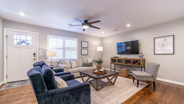 A living room with a sofa, armchairs, a coffee table, and a television. - Cozy cottage, just a short walk to UofA (Fayetteville)