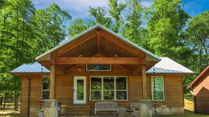 A wooden cabin with a porch, stone steps, and a bench. - Riverside Cabin | Kayaks | Mountains | Stargazing (Nashoba)